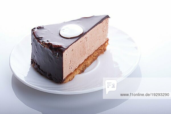 Leckerer Schokoladenkuchen auf dem Teller auf weißem Hintergrund. Unscharfer Fokus