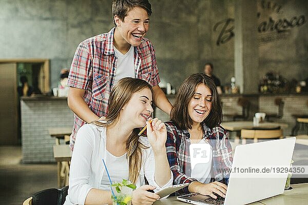 Fröhliche Schüler posieren mit Laptop