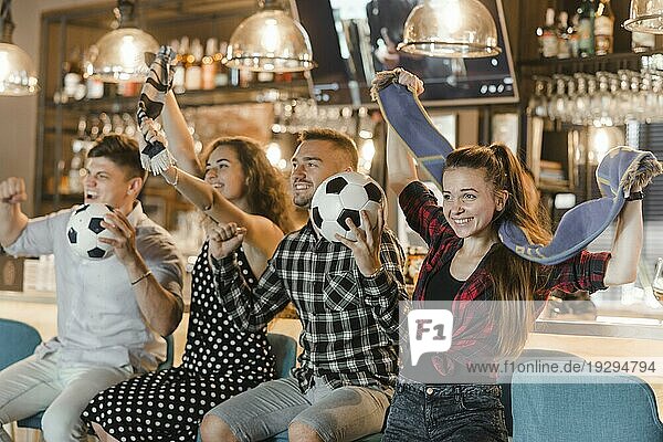 Fußballfans sitzen an der Bar und feiern den Sieg