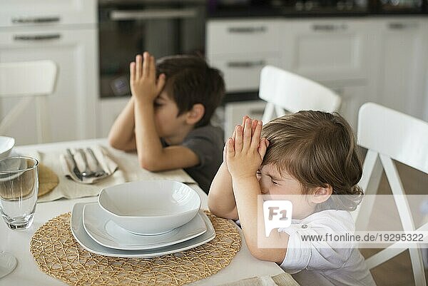 Bezaubernde Kinder beten zu Hause