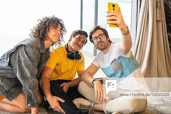 Kreatives junges Unternehmerteam macht ein Selfie auf dem Boden sitzend in einem Haus