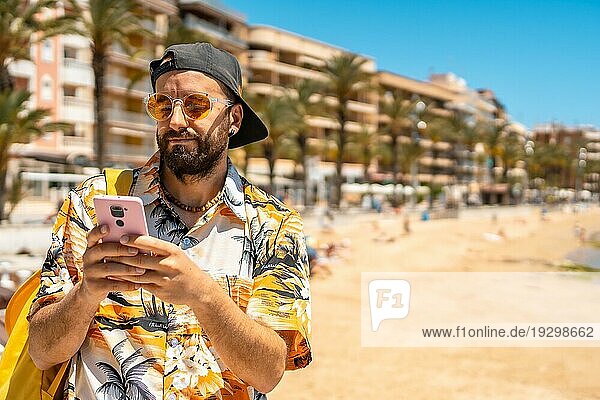 Ein junger Tourist mit dem Telefon am Playa del Cura in der Küstenstadt Torrevieja  Alicante  Valencianische Gemeinschaft. Spanien  Mittelmeer