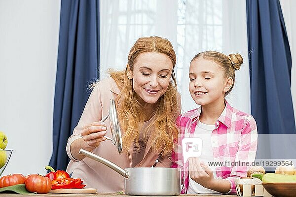 Mutter Tochter riecht an zubereiteten Speisen Küche