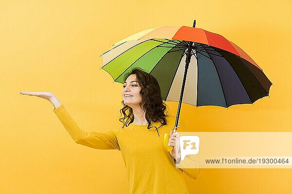 Vorderansicht Frau mit Regenbogenschirm