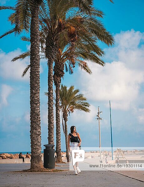 Sommerlicher Lebensstil  brünette Kaukasierin mit weißen Shorts und schwarzem TShirt an der Mittelmeerküste