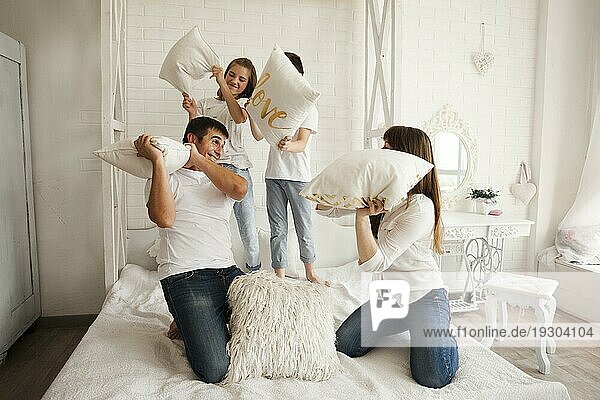 Playful Familie mit lustigen Kissen Kampf Bett