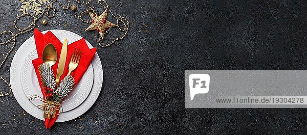 Tabelle Einstellung Banner mit goldenen Besteck und rote Serviette auf dem schwarzen Stein Tisch  Weihnachten oder Neujahr Karte oder Menüvorlage Kopie Raum flach legen