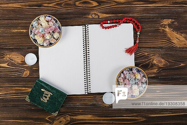 Overhead Ansicht Spirale Notebook mit Freude lukum Schalen kuran roten Gebetsperlen hölzernen Schreibtisch