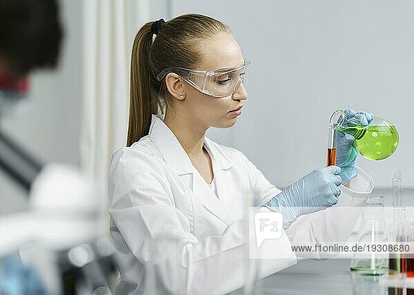 Seitenansicht weibliche Forscherin Labor mit Reagenzgläsern Schutzbrille