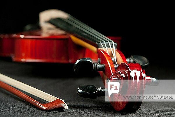 Schöne Geige und Bogen auf dunklem Samtgrund