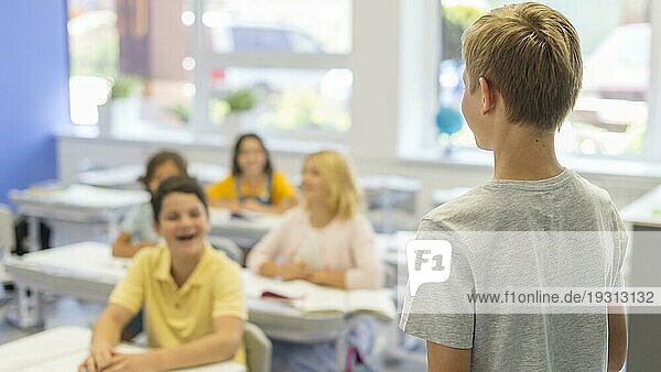 Junge mit hohem Winkel  der seine Klasse präsentiert