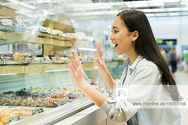 Glücklich ethnischen weiblichen suchen Süßwaren Bäckerei Geschäft