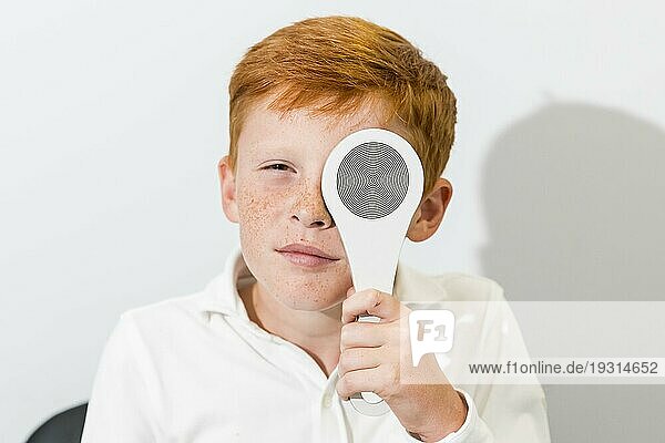Porträt Junge bedeckt Auge mit Okkluder Optik Klinik