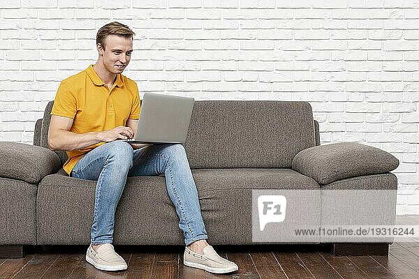Vorderansicht Mann sitzend beim Überprüfen des Laptops