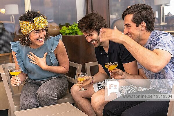 Drei glückliche Freunde haben Spaß in einer Bar während der Ferien