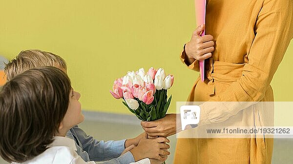 Kinder schenken ihrer Lehrerin einen Blumenstrauß