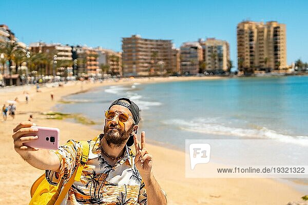Ein junger Tourist macht ein Selfie am Playa del Cura in der Küstenstadt Torrevieja  Alicante  Valencianische Gemeinschaft. Spanien  Mittelmeer