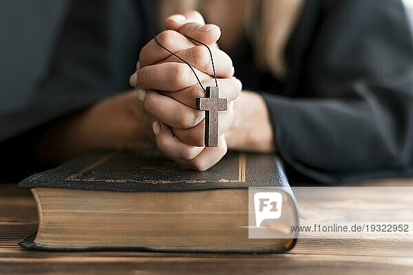 Betende Person mit Kreuz und heiligem Buch