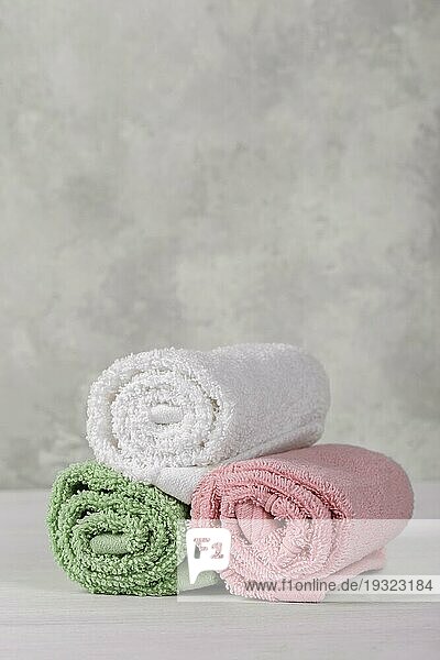 Spa Komposition mit weißen  rosa und grünen weichen gerollten Baumwollhandtüchern  Kopierraum vertikal
