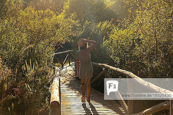 Ein junger Tourist auf einem Holzsteg im Naturpark Doñana  Huelva. Andalusien