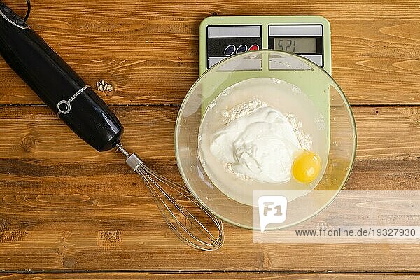 Mehl  Ei  Wasser und saure Sahne in einer Schüssel auf einer Küchenwaage  Ansicht von oben