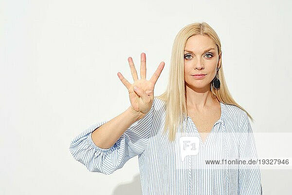 Attraktive blonde Frau zeigt vier Finger. Zählen mit Fingern
