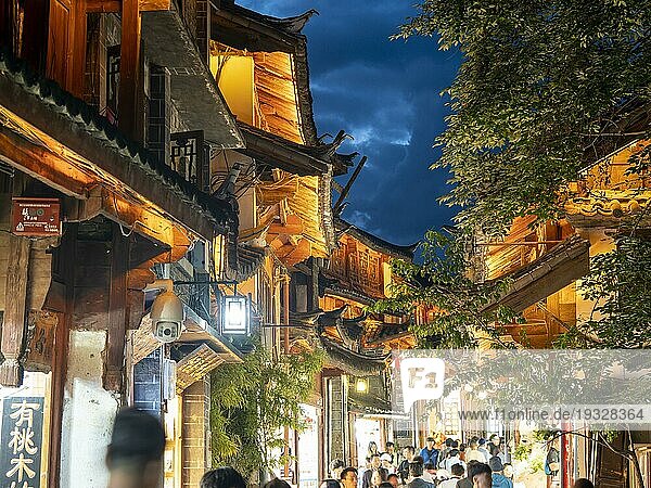 Alte beleuchtete chinesische Holzhäuser  viele Menschen in den Gassen  historischen Altstadt von Lijiang  Yunnan  China  Asien