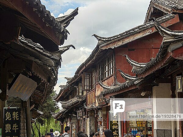 Gassen mit alten chinesischen Holzhäusern und bummelnden Passanten  historische Altstadt von Lijiang  Yunnan  China  Asien