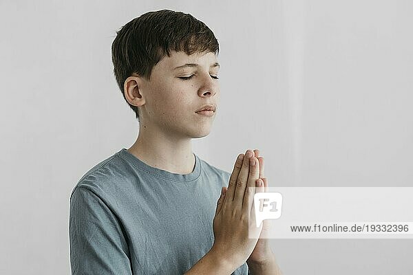 Kleiner Junge betet in einem Haus