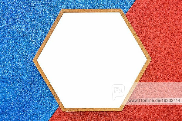 Leere hölzerne Sechseck Rahmen rot blauem Hintergrund