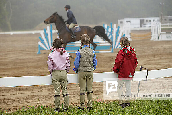 Three girls watch a horse show in Westbrook  Connecticut.