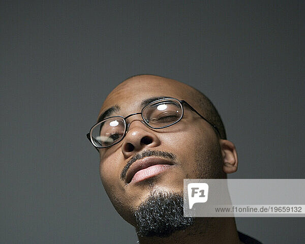 Portrait of a young African American man wearing glasses.