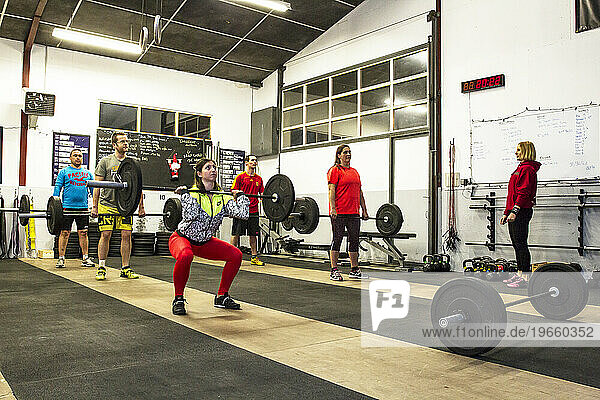 Coach supervising a weightlifting movement during a crossfit class