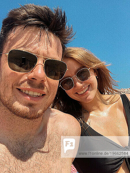 Couple's beach selfie on a sunny day  capturing beach love
