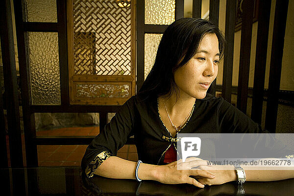 A woman sits at a table in a traditionally decorated restaurant in Taichung  Taiwan.
