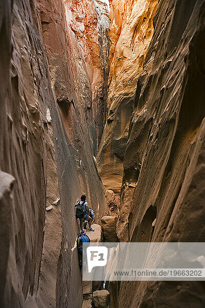 Three people in a slot canyon  Utah.