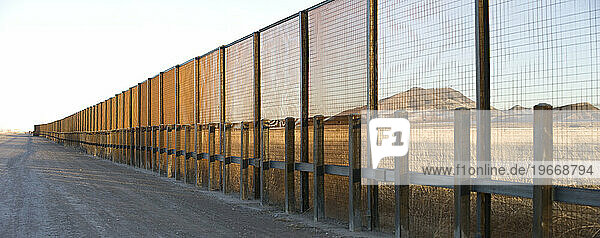 A pedestrian-style fence runs along the Mexican border in Arizona.