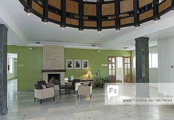 Modern building interior  hotel  reception area  pillars and tiled floor  fireplace and atrium.