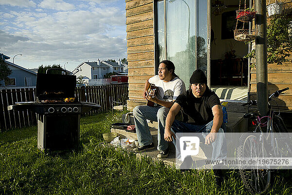 Two young men sit on the back step in Fort McMurray.
