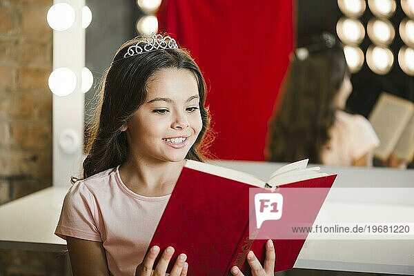 Junges lächelndes Mädchen liest Buch