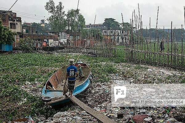 Bauarbeiter transportieren Sand aus einem Boot über eine Planke  Tel Ghat  Dhaka  Bangladesch  Asien