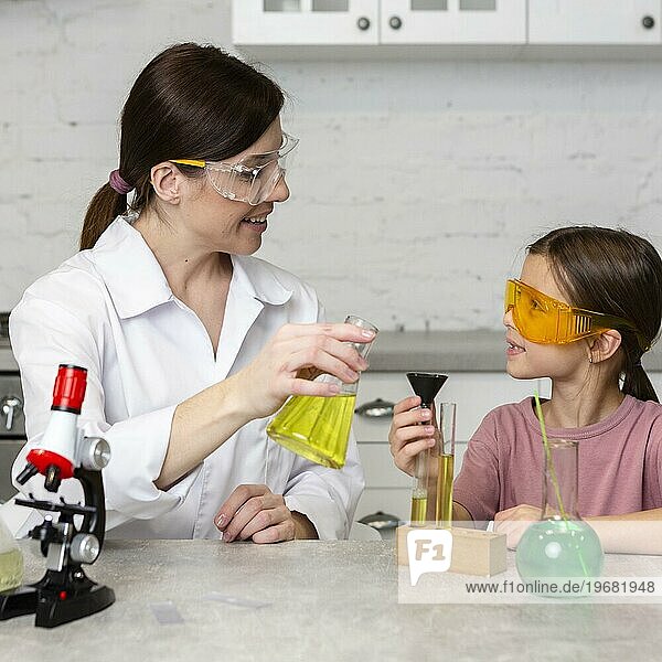 Kleines Mädchen weiblichen Lehrer tun Wissenschaft Experimente mit Reagenzgläsern