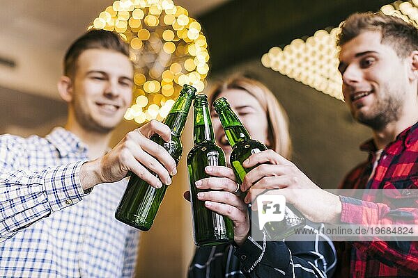 Niedriger Winkel Ansicht glücklich Freunde clinking Flaschen Bier