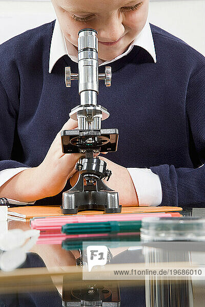 Schoolboy looking in a microscope