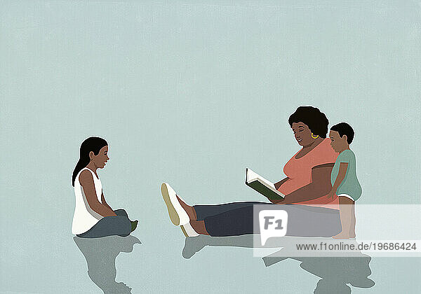 Black mother sitting and reading book to daughter and baby son