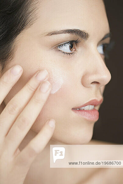 Close up of a woman applying moisturiser on her face