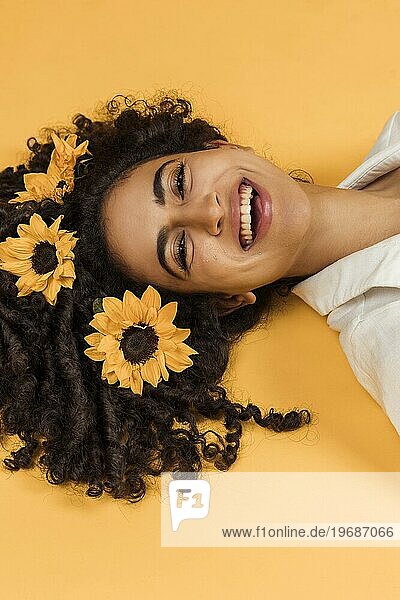 Attraktive fröhliche Frau mit Blumen Haar