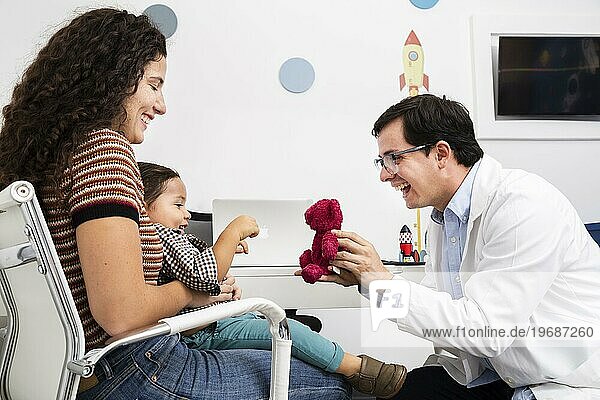 Seitenansicht Arzt spielt mit Baby Junge