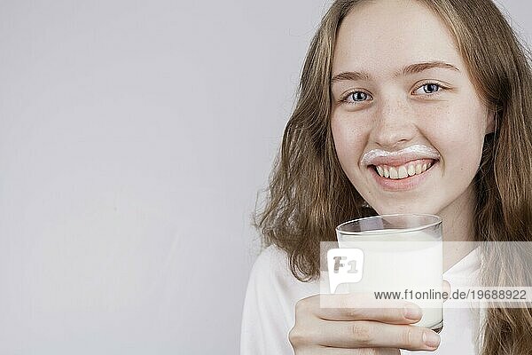 Vorderansicht blondes Mädchen hält Glas Milch