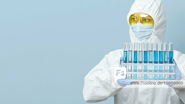 Vorderansicht eines Wissenschaftlers mit blaün Chemikalien in der Hand und Kopierraum